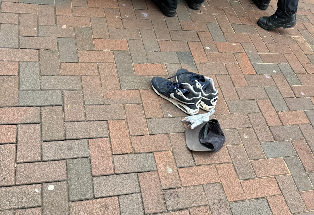 A police evidence bag and items of clothing were seen next to a police van